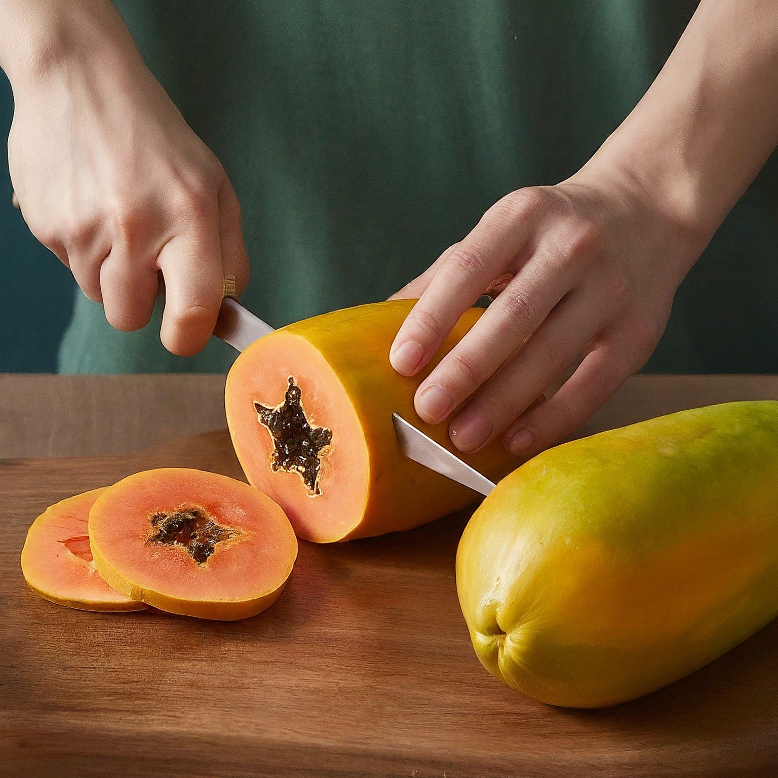 A ripe papaya cut open showing orange flesh and black seeds.